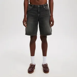 Detailed front view of men's washed grey denim shorts styled with brown boat shoes