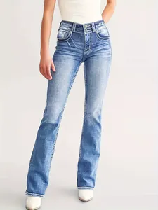 Detail der blauen Slim-Flare-Jeans für Damen mit weißer Stickerei und doppeltem Knopfverschluss.