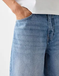 Detailed macro view of men's light blue washed denim shorts showing pocket and stitching