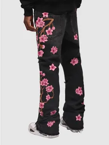 Detailed back view of men's black straight jeans with pink floral embroidery.