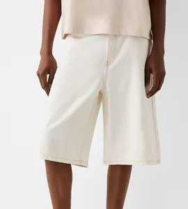 Detail view of men's loose-fit off-white denim shorts with clean stitching.