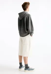 Back view of men's wide-leg white denim shorts with large back pockets and relaxed fit