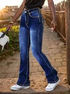 Dettaglio di jeans svasati blu da donna con ricamo sulla tasca e cuciture a contrasto.