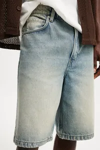 Close-up of men's washed light blue denim shorts with professional textured finish.