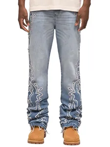 Dettaglio dei jeans dritti da uomo con lavaggio sfumato blu e ricami bianchi laterali