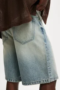 Detailed macro shot of light blue washed denim shorts with relaxed fit for men