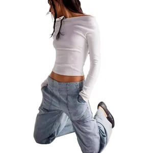 Fashionable white off-shoulder long sleeve top paired with loose low-waist cargo jeans