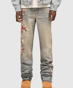 Detailed view of men's straight-leg jeans with floral and crane embroidery accents.