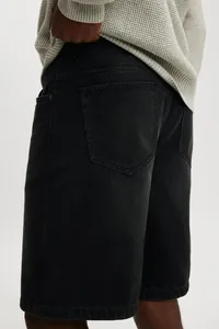 Close-up detail shot of men's black denim shorts showing rear pocket fabric texture