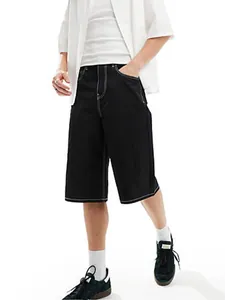 Detail of men's black denim shorts featuring white contrast stitching and loose fit