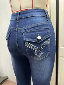 Primo piano di jeans in denim blu da donna con ricami geometrici sulle tasche posteriori.