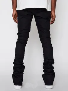 Back view showing the fabric folds of men's black streetwear stacked denim jeans
