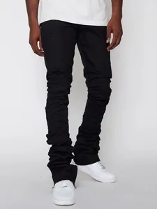 Detailed macro view of men's black stacked denim jeans showing unique pleated leg fold details