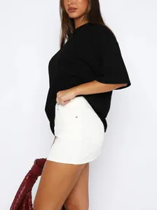 Mini-jupe en jean blanc extensible à taille haute avec une silhouette moulante