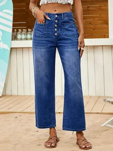Detail view of women's blue high-waist cropped jeans featuring a stylish button fly