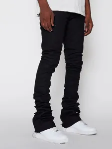 Detail view showing the stacked scrunch effect on men's black street fashion denim jeans