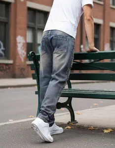 Rear view of men's loose blue distressed jeans in an urban street setting
