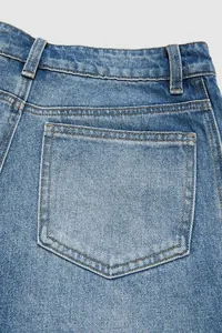 Close-up detail shot of the back pocket on vintage washed blue denim jeans for women