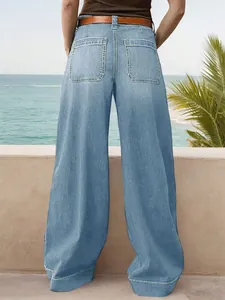 Back view of women's loose wide-leg denim jeans in a coastal setting
