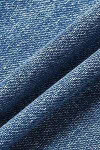 Macro texture shot of blue washed denim fabric showing twill weave for casual jeans