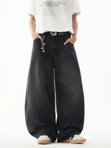 Dettaglio jeans uomo gamba larga retrò, vestibilità comoda e lavaggio grigio sbiadito.