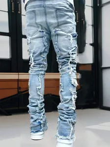 Macro view of light blue distressed stacked denim jeans for men featuring heavy raw edges