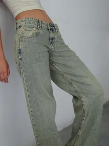 Détail d'un jean en denim à jambe droite et taille haute délavé clair pour femme