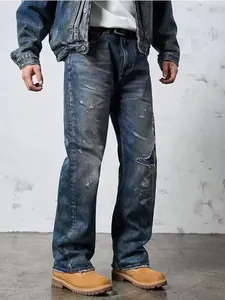 Detailed view of men's vintage distressed wide-leg blue jeans with ripped patchwork design.