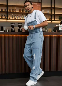 Lifestyle-Aufnahme einer hellblauen Herren-Latzhose mit Rissen in einem modernen Café-Ambiente