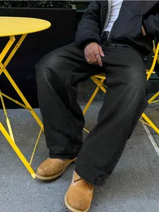 Dettaglio ravvicinato di jeans neri rétro da uomo con gamba larga e vestibilità comoda