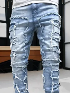 Detailed close-up of light blue distressed denim jeans with fringe raw edges and patches