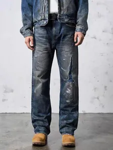 Distressed men's blue denim jeans featuring vintage washed finish and patchwork details