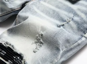 Close-up detail of distressed denim jeans with ripped texture and paisley lining