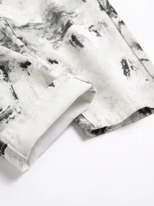 Gedetailleerde close-up van de zoom en het zwarte spatpatroon op een witte denim spijkerbroek
