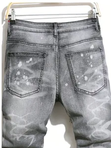 Gros plan d'un jean gris pour homme avec des éclaboussures de peinture blanche
