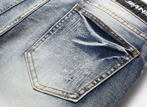 Close-up detail of the back pocket on washed blue distressed slim fit men's jeans fabric