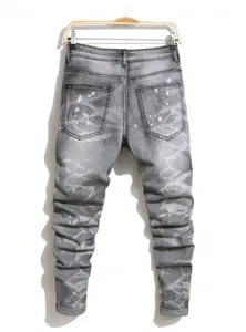 Vue arrière d'un jean slim gris pour homme avec des taches de peinture graffiti blanches.