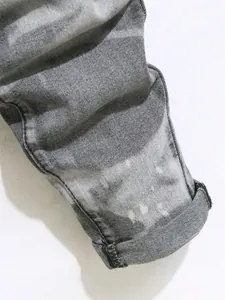Détail macro du revers d'un jean en denim délavé gris avec effet tie-dye blanchi unique