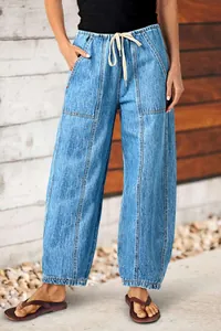 Détail d'un jean en denim à jambes larges pour femmes avec taille élastique à cordon.