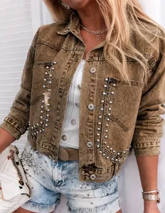 Detailaufnahme einer khakifarbenen Damen-Jeansjacke mit dekorativen Silbernieten und Metallknöpfen