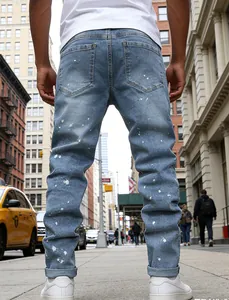 Rear view of slim fit light blue jeans with white paint splatter in urban street setting