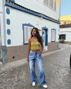 Foto de estilo de vida de unos vaqueros azules de talle alto y pierna ancha con top oliva