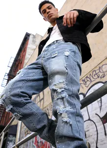Detailed view of men's distressed light blue washed jeans in an urban streetwear style