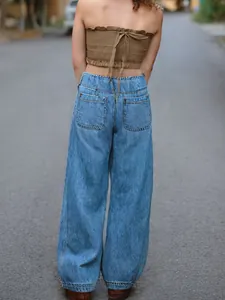 Vue arrière d'un jean en denim à taille haute et jambe large pour femme en plein air