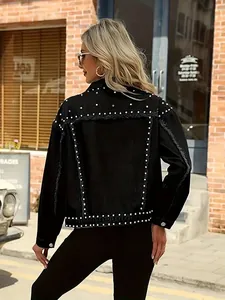 Detail view of a black high street denim jacket with decorative silver rivets on back.