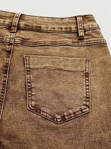 Close-up of vintage brown washed denim jeans showing back pocket and stitching details