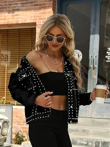 Detailed view of women's black denim jacket with decorative silver studs and high street style