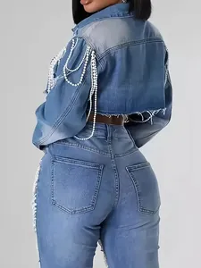 Detailed view of cropped denim jacket featuring elegant white pearl chain fringe