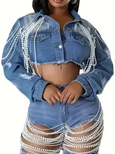Detail showing heavy-duty pearl tassels and fringe on a ripped cropped blue denim jacket