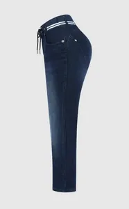 Détail latéral d'un jean denim bleu foncé pour femme avec cordon de serrage rayé.